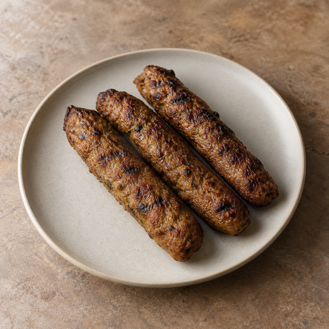 Three seekh kebabs on a neutral plate photographed in a consistent menu style