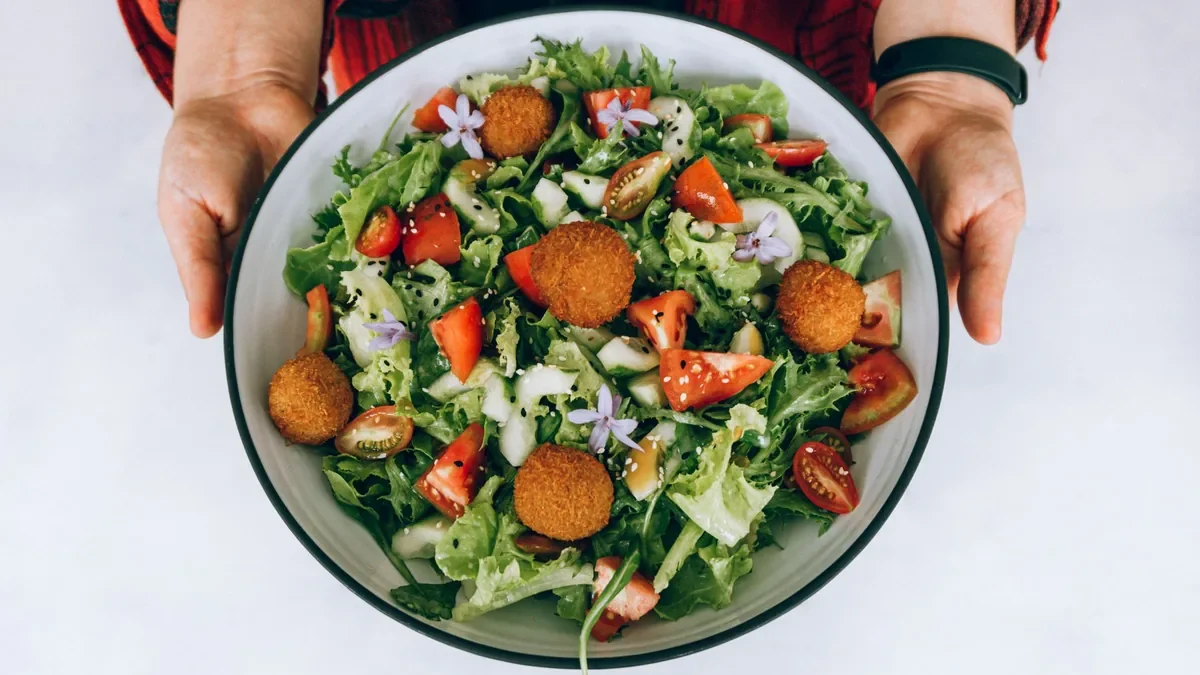 A fresh green salad held in two hands.