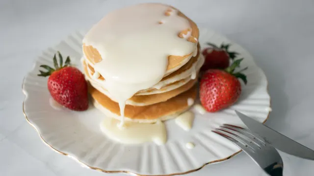 Pancakes with cream and strawberries.