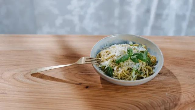 Pasta in a small bowl on a wooden table.